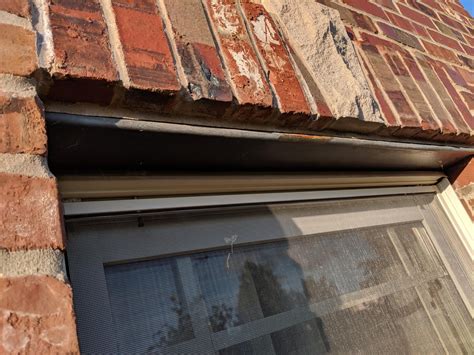 metal hardware above windows of an old house|rust plate on top of window.